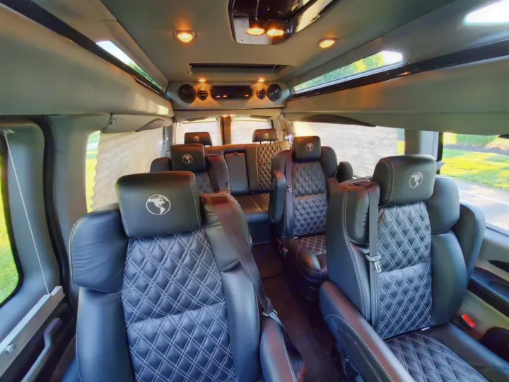 RV rental: Plush, spacious interior with black leather diamond-stitched captain's chairs. Bright light fills the cabin.. Chevy Luxury Splinter Express Express Conversion Van 2024