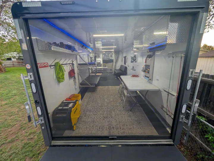 Inside a versatile enclosed trailer, offering mobile work & lounge space. Great RV rental alternative for adventures/events.. Trails West RPM Toy Hauler 2023