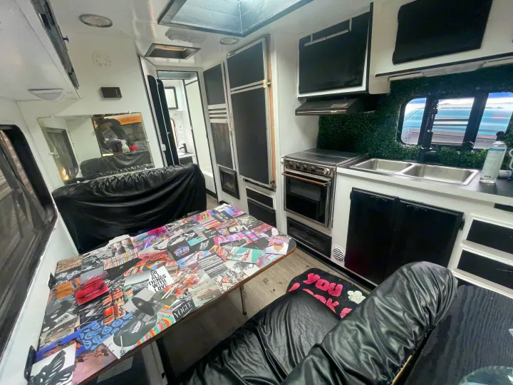 RV rental interior with a compact kitchen, eye-catching collage table, and comfortable lounge seating.. Skyline Century 1985