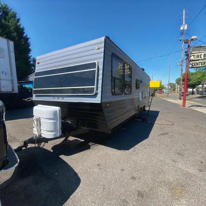 Grey & black travel trailer parked on asphalt. This RV rental is ready for your next adventure.. Skyline Century 1985