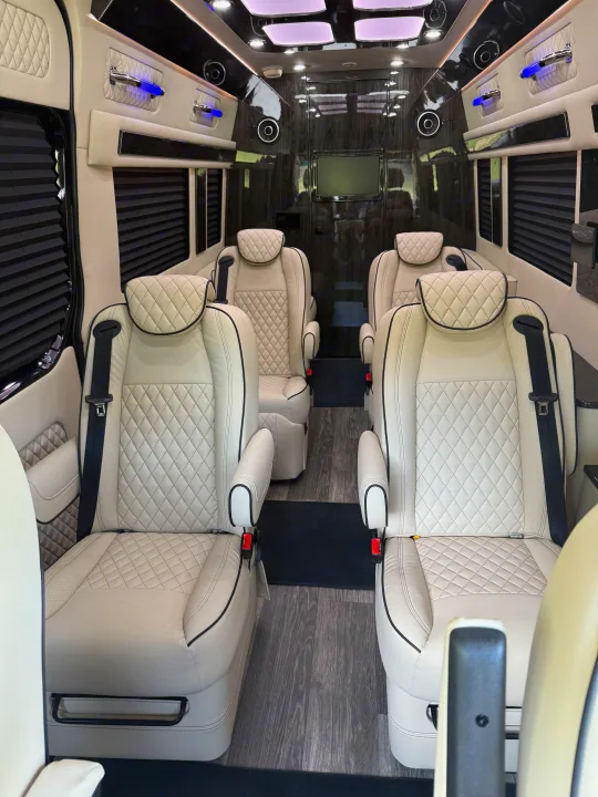 Luxurious RV rental interior featuring quilted leather captain's chairs, wood accents, and ambient lighting for comfortable travel.. Mercedes-Benz Sprinter 2025
