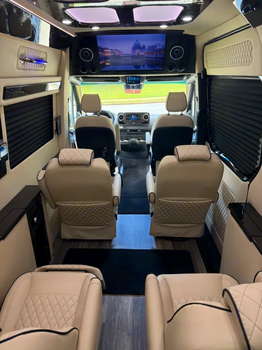 Step inside this upscale RV rental: a spacious interior with plush, quilted seats, a large entertainment screen, and elegant finishes.. Mercedes-Benz Sprinter 2025