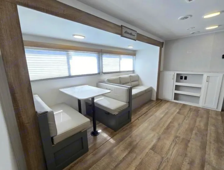 Cozy rv rental interior featuring a bright dinette, comfortable sofa, and built-in storage. Ideal compact living space.. Heartland RVs Eddie Bauer EBS 261BH 2024