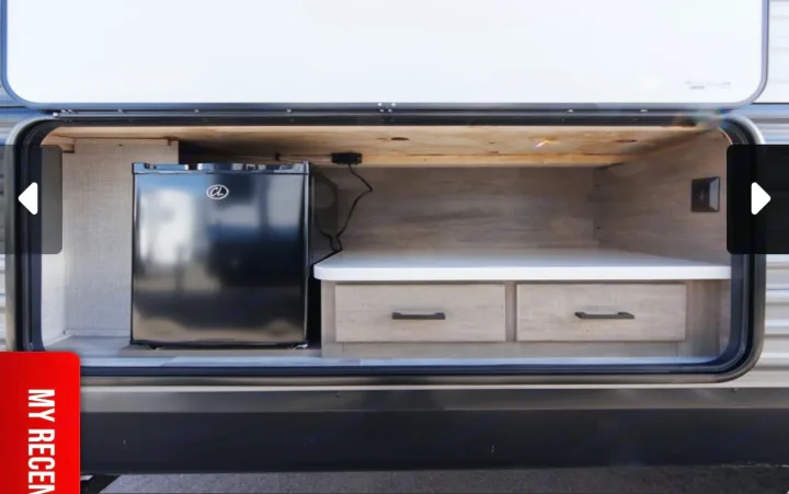RV rental's accessible exterior compartment with a mini-fridge, countertop, and convenient storage drawers.. Jayco Jay Flight SLX 2025