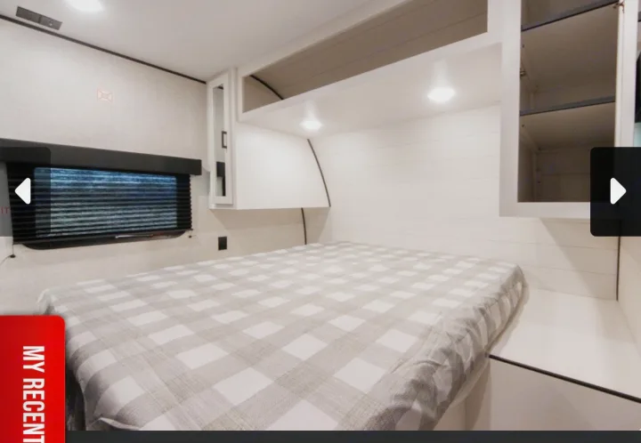Cozy RV rental bedroom with a plaid bed, overhead storage, and a window with blinds.. Jayco Jay Flight SLX 2025