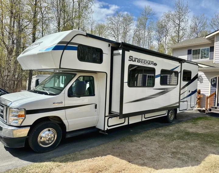 Sunseeker RV rental: A white Class C motorhome parked on a paved driveway next to a house, ready for adventure.. Forest River Sunseeker LE 2021