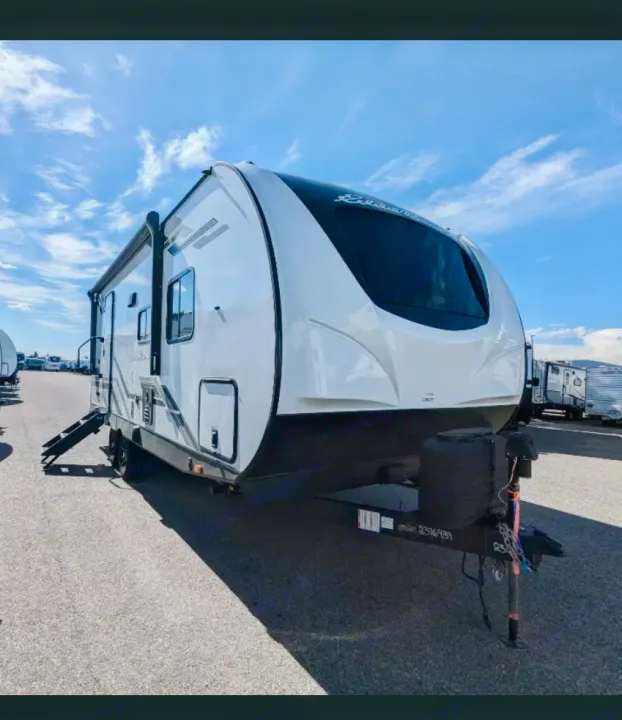 This modern white and black travel trailer, seen on a sunny RV sales lot, is ready for your next rv rental adventure.. Heartland RVs Eddie Bauer 2024