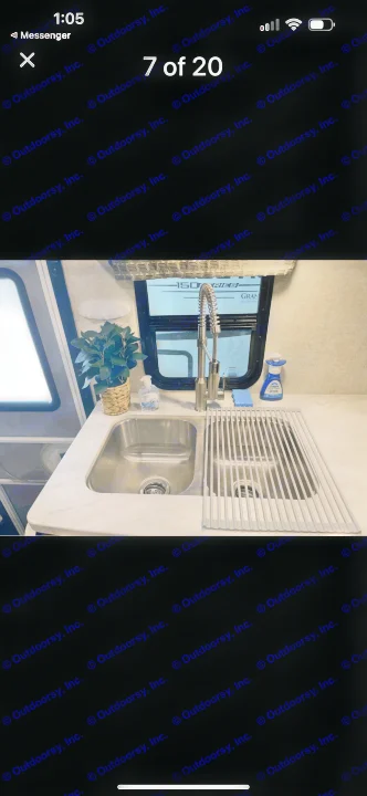 Clean, modern kitchen sink area inside an RV rental, featuring a double sink, faucet, and roll-up drying rack.. Forest River Sunseeker LE 2019