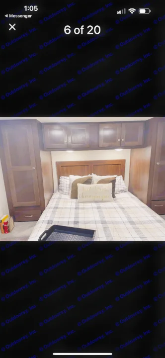 Cozy RV rental bedroom featuring a plaid bed, wood cabinets, and built-in storage. Perfect for a mobile home getaway.. Forest River Sunseeker LE 2019