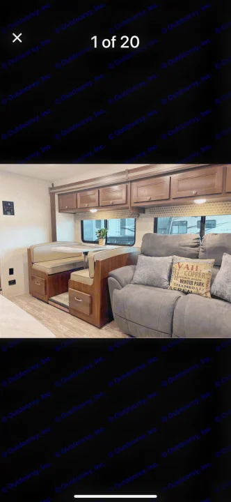 RV rental interior: A light dinette booth with wood storage, overhead cabinets, and a grey recliner sofa with decorative ski pillows.. Forest River Sunseeker LE 2019