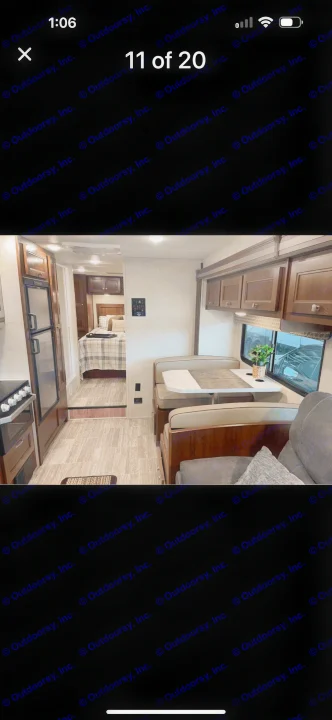 This rv rental interior features a kitchen, dining booth, and cozy rear bedroom with plaid bedding, showcasing the living space.. Forest River Sunseeker LE 2019