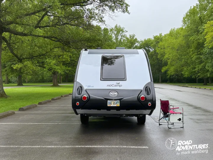 Relaxing with a nuCamp T@B teardrop rv rental in a lush green park on an overcast day.. nuCamp T@B 2025