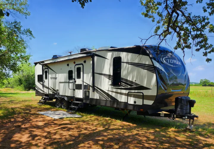 Spacious white & black Torque RV rental parked in a grassy, shaded outdoor area, ready for adventure.. Other Other 2019