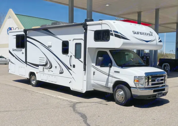 This white Sunseeker RV rental, perfect for road trips & camping, is parked under an awning on a sunny day.. Forest River Sunseeker LE 2019