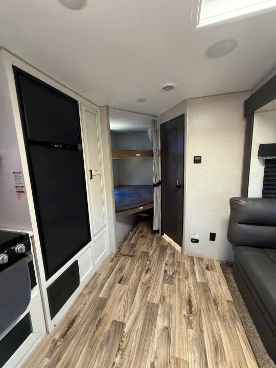 Step inside an RV rental! This spacious interior features a full kitchen, a dedicated bunkhouse, and a cozy living area with a sofa.. Sport Trek 270 VBH 2021