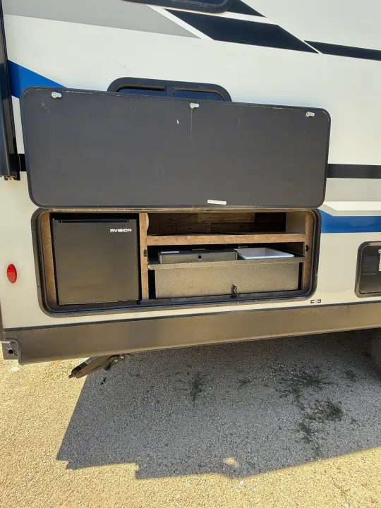 Outdoor kitchen on an RV rental, revealing a compact fridge, pull-out stove, and sink for convenient outdoor cooking.. Sport Trek 270 VBH 2021
