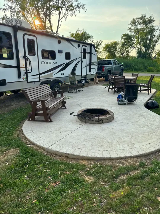 Perfect RV rental setup: a Cougar travel trailer at a spacious campsite with a patio, fire pit, and dining area.. Keystone RV Cougar 2022