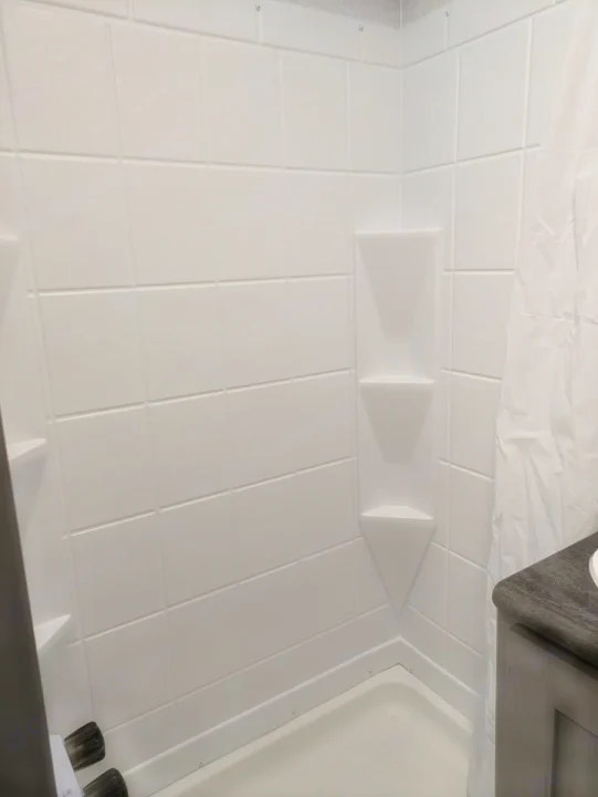 Clean, compact white shower in an RV rental, featuring built-in shelves & molded walls for easy travel.. Forest River Coachmen Clipper 2024