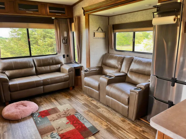 Cozy RV rental living room with plush recliners, sofa, and scenic views, offering a comfortable home-like experience on wheels.. Forest River Sabre 2019
