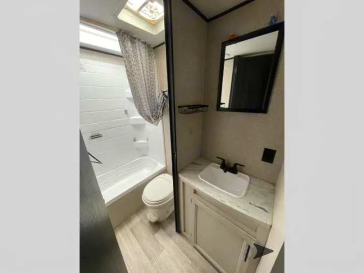 Compact RV rental bathroom featuring a tub/shower, toilet, and vanity with sink. All the essentials on the go.. Jayco Jay Flight SLX 2022
