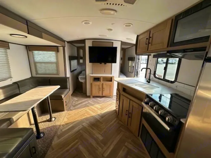 Bright RV rental interior showing a modern kitchen, dinette, & living area with TV.. Cruiser RV Shadow Cruiser 2019