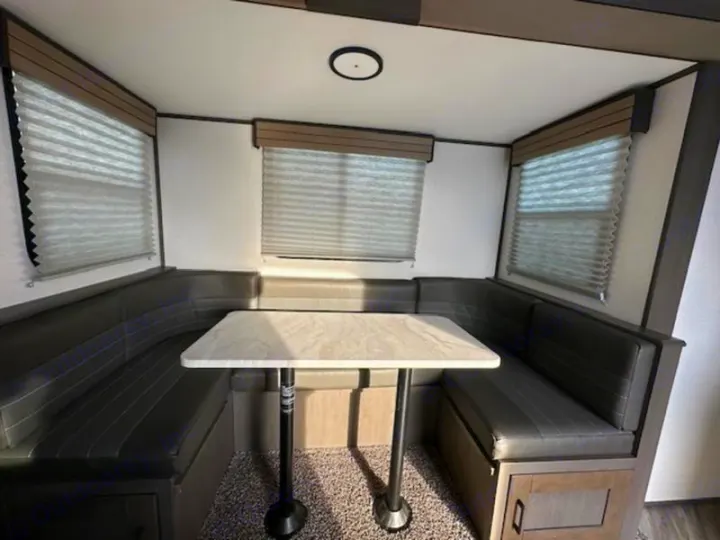 This RV rental features a comfortable U-shaped dinette with dark grey seating & a light table, perfect for dining & relaxing.. Cruiser RV Shadow Cruiser 2019