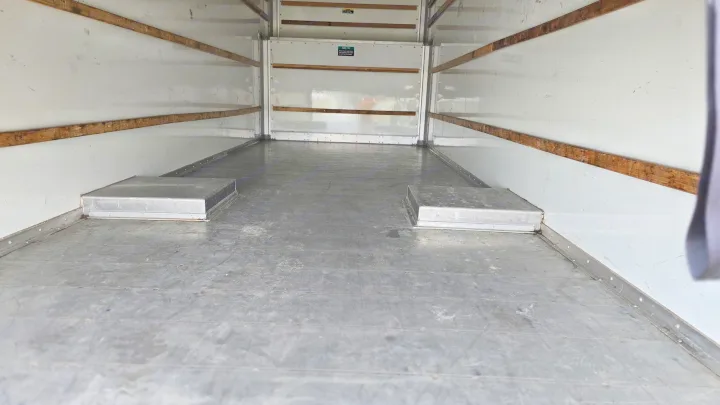 Empty rv rental cargo space with white walls, wooden tie-down slats, and a grey metal floor featuring two raised wheel wells.. Cruiser RV Shadow Cruiser 2019