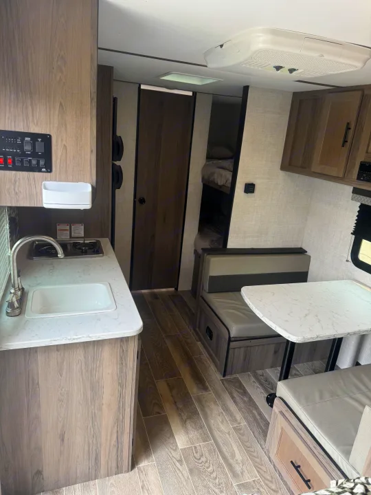 Inside an rv rental: A modern interior with a well-equipped kitchen, comfortable dinette, and cozy bunk beds.. Gulf Stream Ameri-Lite Super Lite 2022