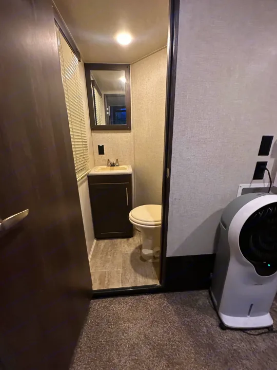 Compact RV rental bathroom with sink, toilet, and modern design. Includes an air purifier for comfort.. Keystone RV Carbon Toy Hauler 2018