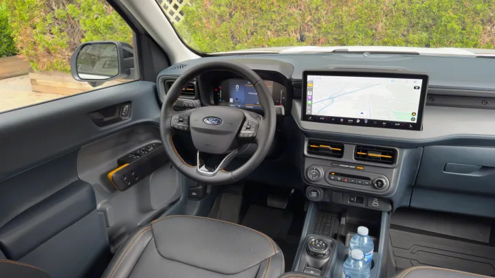 Spacious Ford truck interior, ideal for an rv rental trip. Driver's view of dashboard, large infotainment screen, and digital cluster.. Ford Maverick 2025
