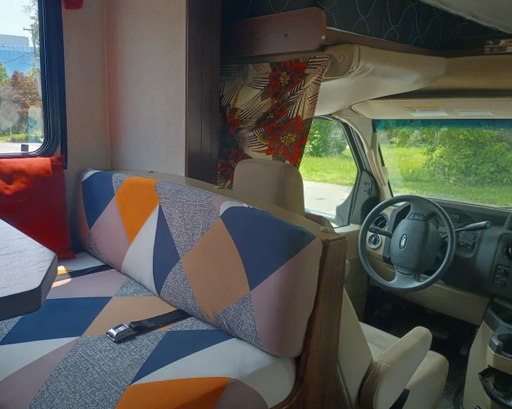 Colorful geometric dinette seating and driver's area inside an RV rental. Ready for a comfortable road trip.. Forest River Sunseeker 2018