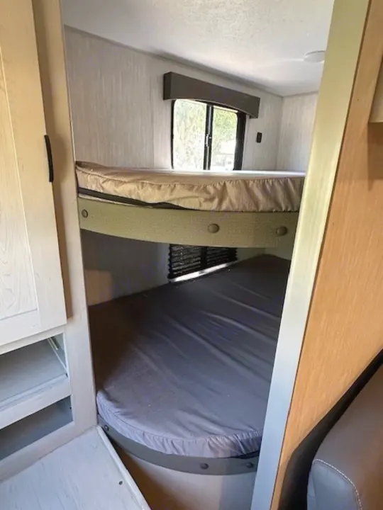 RV rental interior showing two bunk beds, with mattresses, providing compact sleeping for travel.. Forest River Forest River Viking 2025