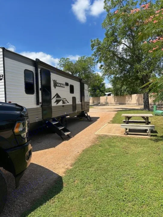 Experience outdoor fun! This rv rental is parked at a spacious campsite with a picnic table.. Forest River Forest River Viking 2025