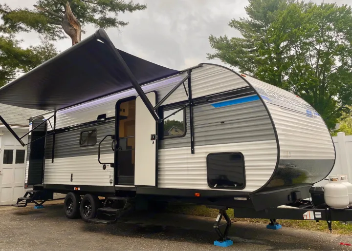 Spacious RV rental, parked outdoors with its awning extended and lights on. It's ready for your next camping adventure.. Heartland RVs Pioneer Trail Blazer 2024