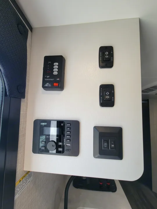 RV rental control panel displaying tank levels, awning & slide-out controls, plus an iRV entertainment system.. Jayco Jay Flight SLX 197MBW Baja Edition 2025