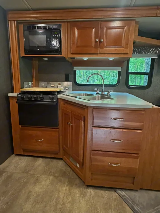 RV rental kitchen: compact, yet complete with microwave, stove, sink, and ample storage for your road trip comfort.. Winnebago Vista 2018