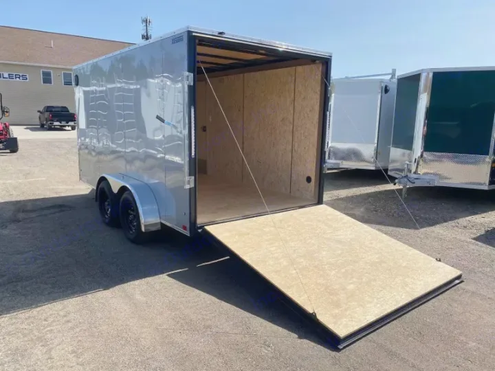 A silver enclosed utility trailer with its rear ramp door open, showing a wood interior. Ideal for versatile hauling, like for an RV rental business.. ITI Cargo 7X14 2025