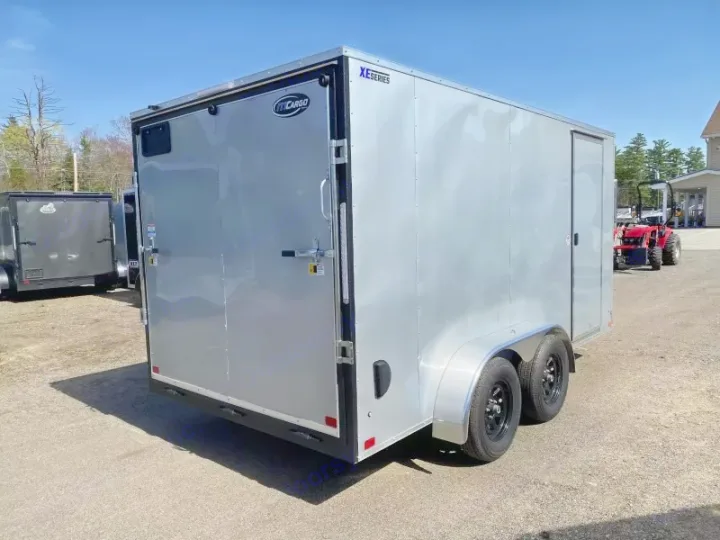 A bright silver enclosed cargo trailer, featuring dual axles & rear ramp door, parked outdoors. Ideal for your next rv rental adventure.. ITI Cargo 7X14 2025