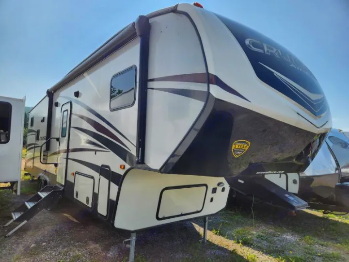 A white and black fifth-wheel RV, a Cruiser Aire model, is ready for an RV rental adventure. Steps are down.. Crossroads RV Cruiser 2019
