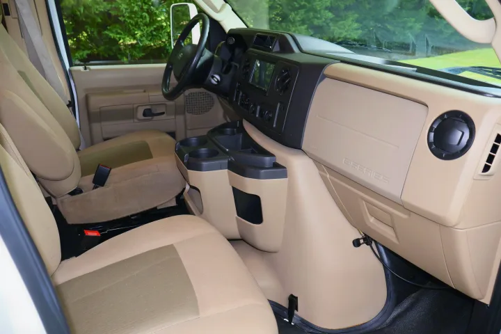 Interior of an RV rental: driver and passenger cabin with beige seats, steering wheel, and dashboard.. Other Freelander 2016