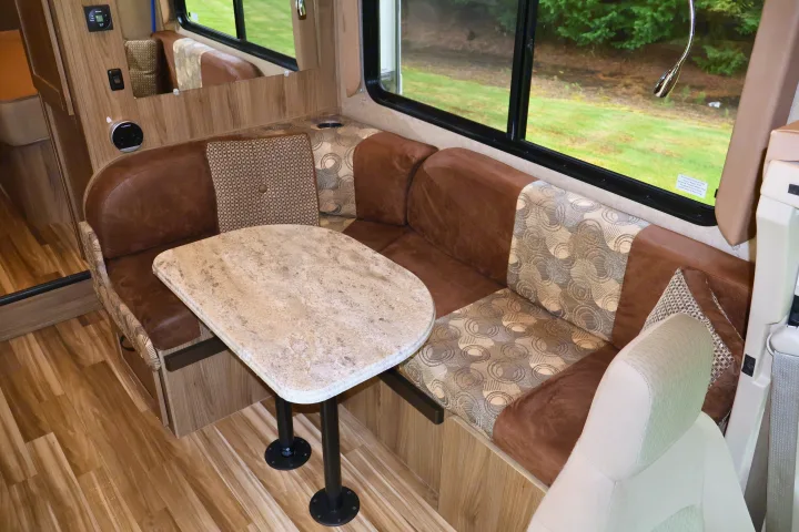 Explore in comfort! RV rental interior with a spacious dinette, plush seating, and scenic views for your next adventure.. Other Freelander 2016