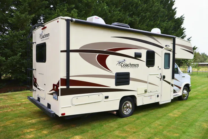 Cream Coachmen Freelander rv rental parked on grass. This Class C motorhome camper offers adventure.. Other Freelander 2016