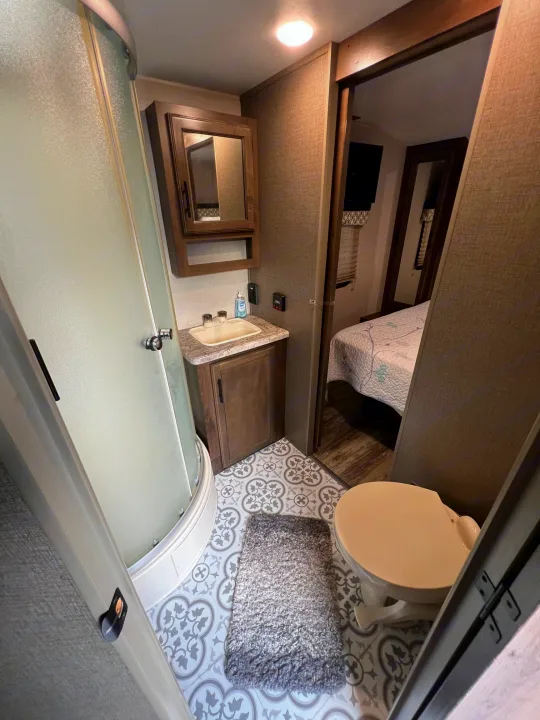 Compact rv rental bathroom with a full shower, sink, toilet, and an adjacent bedroom view.. KZ Connect RLK 24 2019