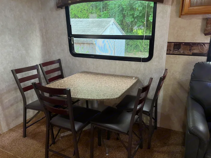 RV rental: Spacious dinette with four chairs, speckled table, and large window. Features brown carpet.. Keystone RV Sprinter Select 2010