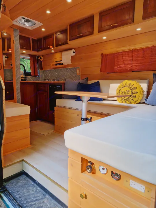Step inside this custom wood RV rental. Features a cozy kitchen, dining, and sleeping area with smart storage and amenities for mobile living.. Dodge Sprinter Van 2008