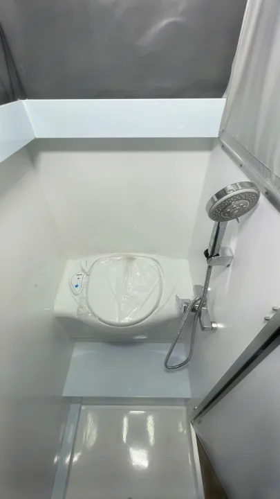 This RV rental's compact wet bath includes a toilet (covered), shower, and integrated shower pan, maximizing small space utility.. Zoomies Campers Eagle’s Nest 2025