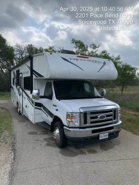 White Coachmen Freeland motorhome RV rental parked on a paved road, ready for a Texas outdoor adventure.. Coachmen Freelander 2021