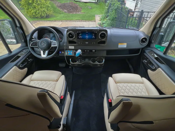 Spacious Mercedes-Benz **RV rental** interior with cream quilted seats and a modern cockpit dashboard, ready for your adventure.. Ultimate Toys Ultimate Coach 2024