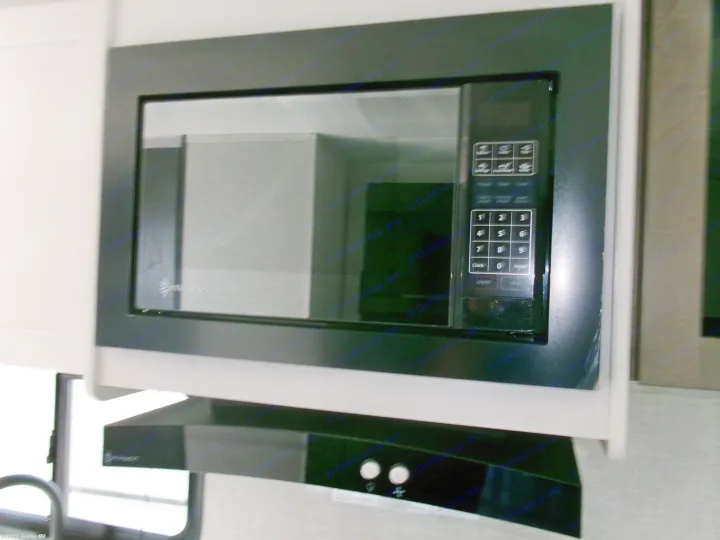 Modern Invision microwave and range hood in a compact RV rental kitchen, perfect for road trip cooking.. Jayco Jay Flight SLX 210 QB 2025