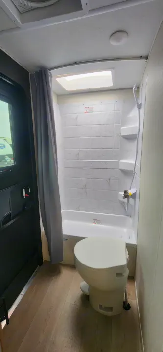 RV rental bathroom: Compact, clean, featuring a tub/shower, toilet, and skylight. Ready for your trip.. Forest River Cherokee Grey Wolf 2026